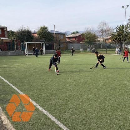 Niños jugando hockey sobre pasto sintético verde de 20mm, resistente, duradero y libre de químicos.