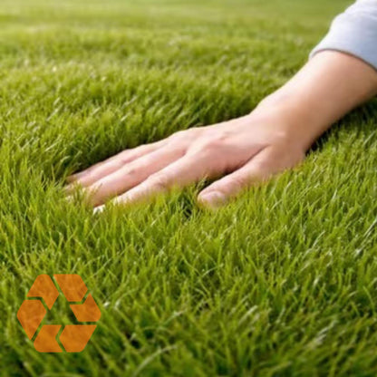 Mano tocando pasto sintético verde de 40mm, suave y realista, ideal para jardines ecológicos y duraderos.