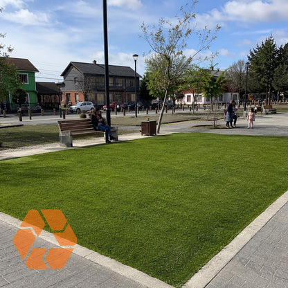 Pasto sintético verde de 7mm instalado en un parque, resistente a rayos UV y con acabado realista para exteriores.