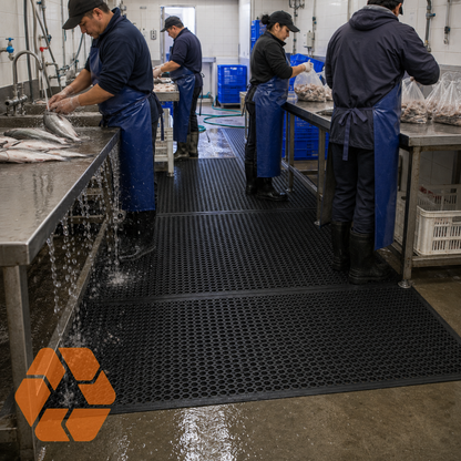 Piso de goma antifatiga negro con diseño drenante, ideal para cocinas industriales y áreas de trabajo húmedas.