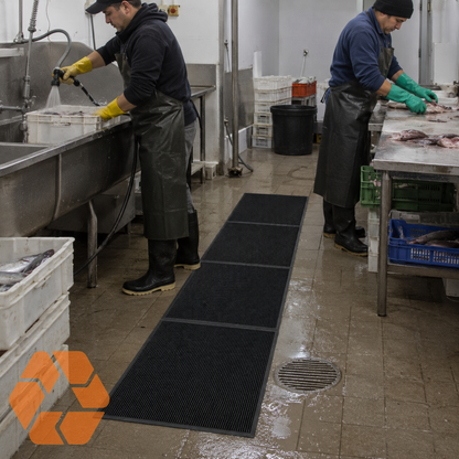 Piso de goma negro antideslizante de 16mm para cocinas industriales, resistente a líquidos y con diseño modular drenante.