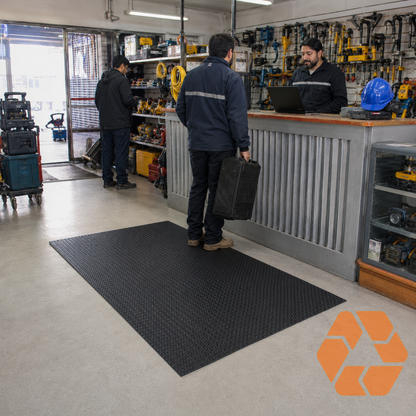Piso de goma negro antideslizante con textura estoperol, ideal para zonas de alto tráfico industrial y comercial.